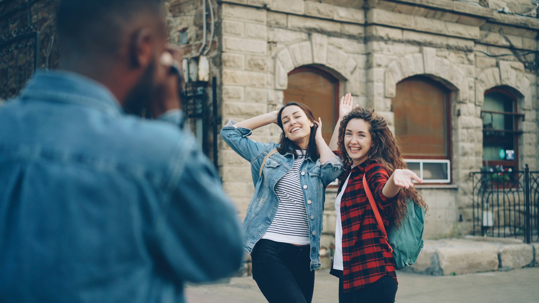 Friends stop for a photograph on a city street