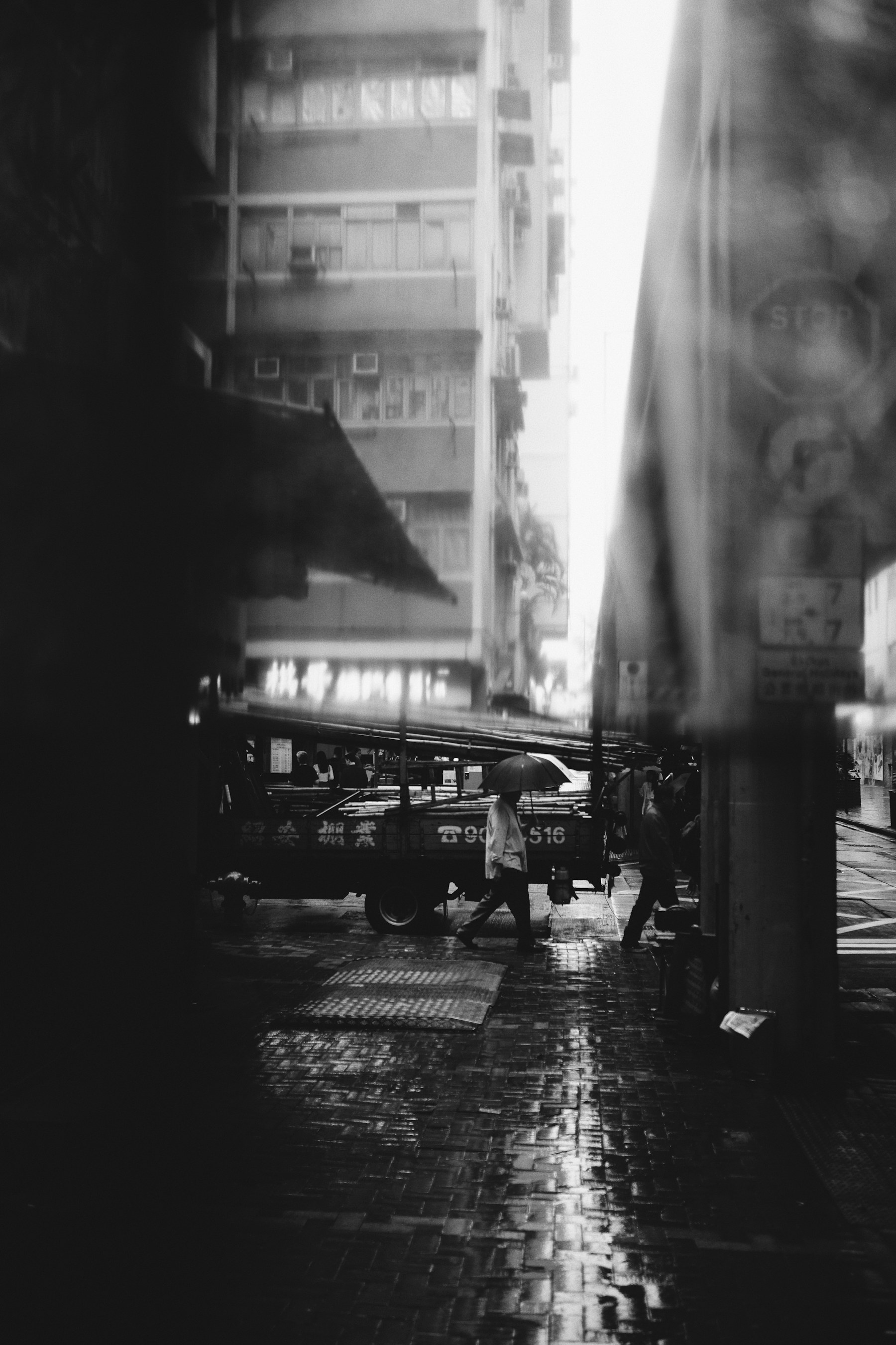 Rainy street seen through an umbrella in black and white